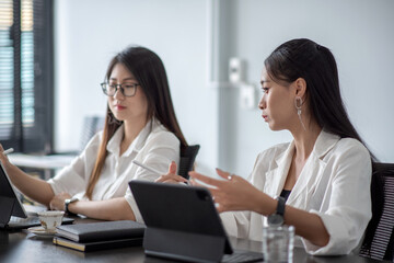 Fototapeta premium Two young asian businesswoman discussing new business projects during at office meeting.