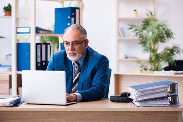 Old male bookkeeper unhappy with excessive work at workplace