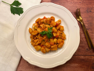Oven baked gnocchi with chicken strips, tomato sauce, vegetables and cheese.