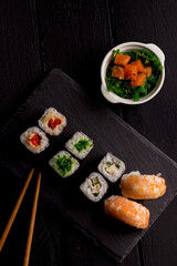 Sushi Set sashimi and sushi rolls on stone slate