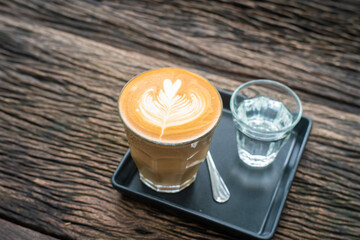 Shot of hot latte art espresso coffee on wood background
