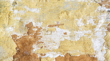 A shot of a Worn, old wall with cracked paint and plaster. Old Sepia photo. The background for the texture looks like a retro photo in yellow and brown tones.  