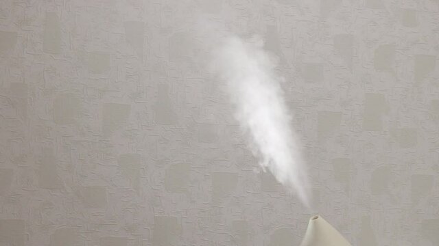 A fallow jet is emitted from the humidifier. An ultrasonic humidifier atomizes water vapor. Illuminated steam.