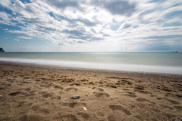 Obraz premium Sunny day with mesmerizing waves on the sea coast.