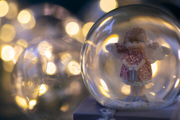 decorative snow globe with a girl angel on a dark wooden background