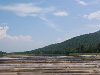 Green hill, blue sky, white clouds, and a reservoir with a defocus bamboo wooden terrace - relaxing landscape