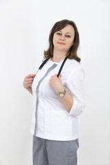 Adult female doctor with a stethoscope against a white wall. experienced doctor who inspires confidence. Woman hospital worker looking at camera.