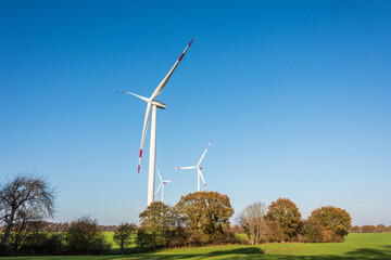 Obraz premium Windpark auf einem Feld in Schleswig-Holstein im Herbst vor strahlend blauem Himmel