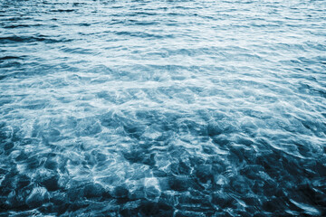 Sea wave background. Calm waves on shallow water. Ripples on lake water. Blue lake surface texture. Outdoor summe ocean perspective backdrop.