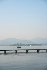The mountain and lake landscape at West Lake in Hangzhou, China, on a sunny day.