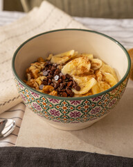 close up of a porridge bowl with banana, chocolate chips and walnuts.