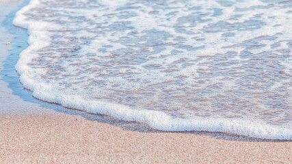 the waves of the sea on the sandy beach on a sunny day