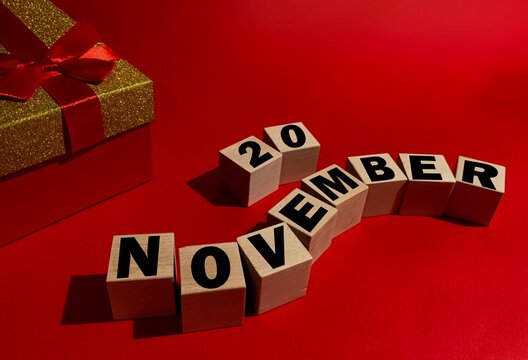 November 20 on wooden cubes ,red gift box on a red background.Autumn .Calendar for November.