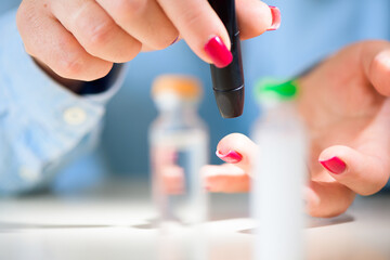 Examine sugar. Blocking sugar testing, woman finger lancet punctures. Close up.