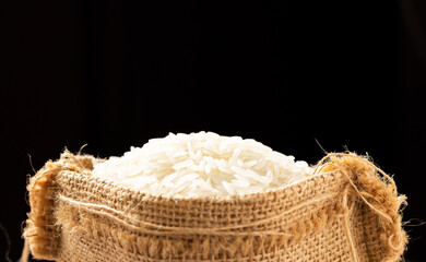 White rice in a sack on black background