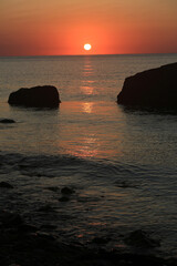 Beautiful sunrise over the sea and stones in the water