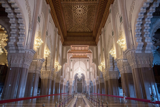 Casablanca, Morocco - November 18, 2018: Inside Hassan II Mosque interior corridor with columns. Arabic arches, ornaments, chandelier and lighting. It is the largest mosque in Maroc.
