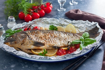 whole baked carp in foil with lemon in the oven, horizontal