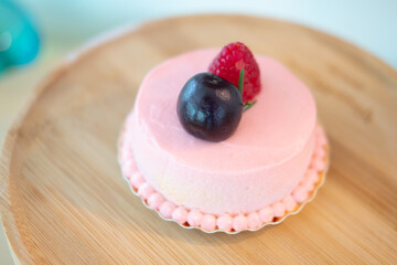 Cream rose mousse dessert on top with raspberry