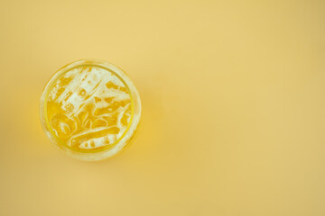 A glass of beer on yellow background.