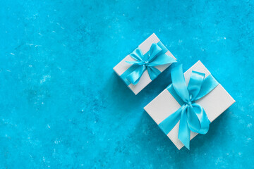 Holiday gifts with blue ribbon on a blue grunge background. Christmas composition. Top view, flat lay, copy space.