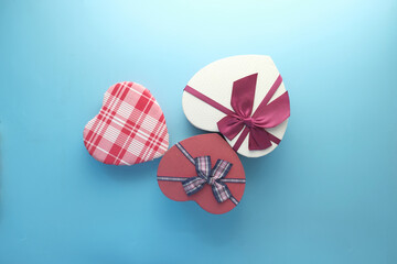 top view of open heart shape gift box on blue background 