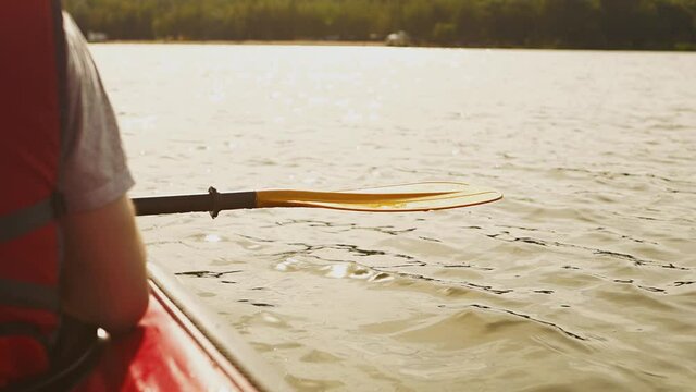 Close-up of a man holding a yellow kayak paddle