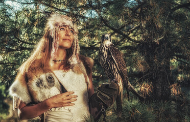 beautiful shamanic woman with eagle in the nature.
