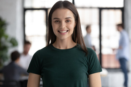 Headshot portrait profile picture of happy young woman employee student standing in office college university at workday looking at camera satisfied proud of being staff member getting good education