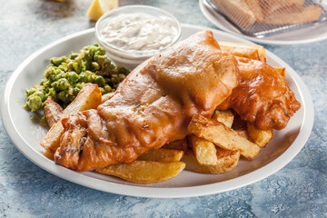 Fish in beer batter and chips with green pea and tartar sauce