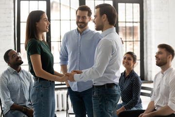 Happy young man succeeded in getting rid of addiction depression holding hands of female with same problem giving support hope on recovery under control of professional psychologist at group therapy.