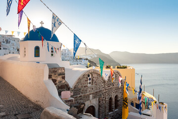 Blue dome church decorated with flags for a religious celebration in Oia, Santorini
