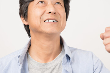 笑顔でガッツポーズをする中年男性