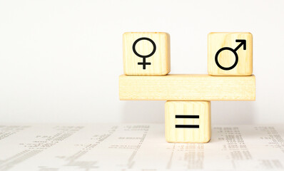 Concept of gender equality. Wooden blocks with male and female symbols on a balanced seesaw on white background.