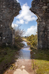 Flooded footpath through a ruined archway