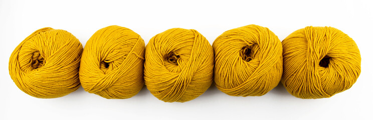 Composition from balls of yarn for knitting yellow on a white background top view. Copy space.