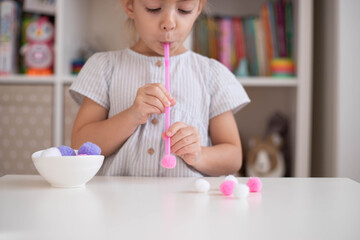 Fun game for preschooler. Child girl play the straw and pom pom counting  game. Home made...