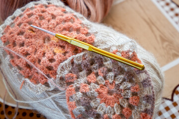 Close-up, grey and multi colored yarns and crochet needle. 