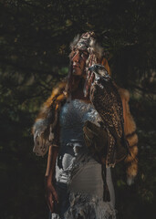 beautiful shamanic woman with eagle in the nature.