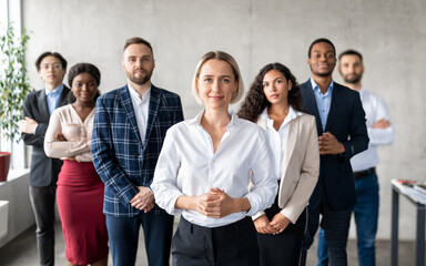 Successful Businesswoman Standing In Front Of Business Team In Office - obrazy, fototapety, plakaty