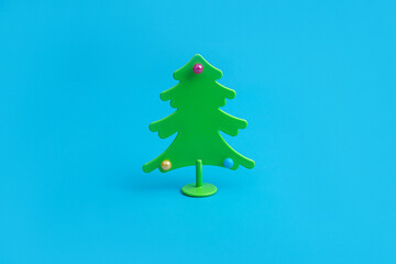 Creative layout with a Christmas tree on a bright blue background. Minimal winter nature holiday scene.