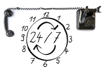 Rund um die Uhr telefonisch erreichbar dargestellt mit einer Uhr und einem alten Telefon auf weißem Hintergrund