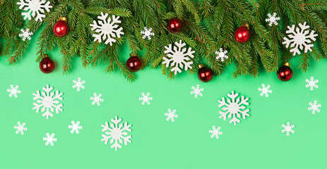 Banner Christmas flatlay copyspace. Red Christmas toys and Snowflakes sprigs of spruce on a green background. Copy space. Christmas frame. Design elements.