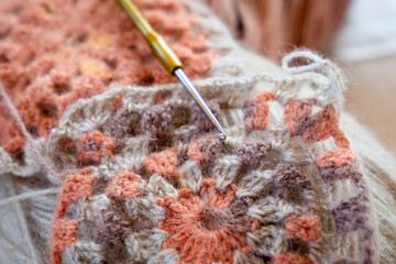 Close-up, grey and multi colored yarns and crochet needle. 