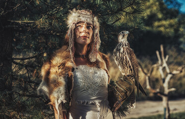 beautiful shamanic woman with eagle in the nature.