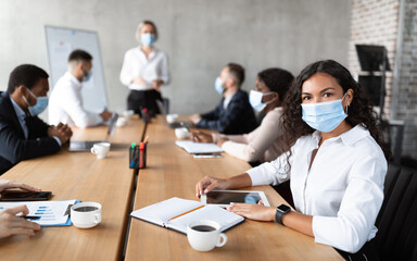 Businesswoman In Face Mask Sitting Attending Corporate Meeting In Office - Powered by Adobe