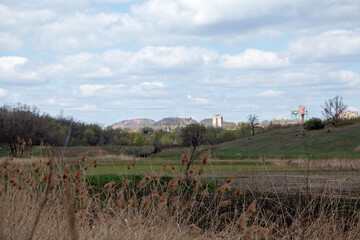 Fototapeta premium green grass on slopes of ravine. Behind mountains