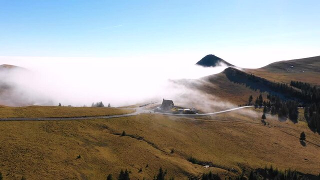 Beautiful chalet at the edge of sea cloud on top of the mountain. Touristic place in the Bucegi mountains Romania. Amazing sea clouds on the summit. Thermal inversion phenomenon on top of the mountain