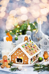 Homemade Christmas gingerbread house with holiday   decorations, candles and lanterns on  background