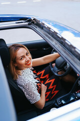 Young woman driving with sunroof open